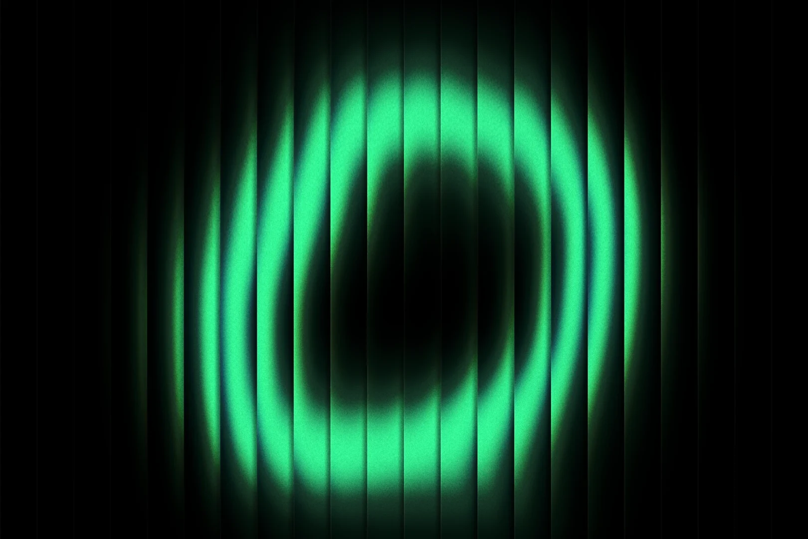 Anneau de lumière verte vu à travers des lames de verre cannelé, sur fond noir