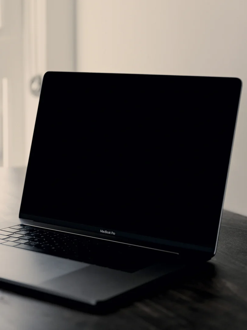 Open laptop on a wooden table near a window