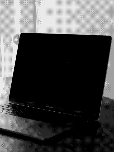 Open laptop on a wooden table near a window